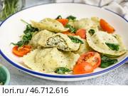 Тарелка вкусных равиоли с овощами на сером фоне. Стоковое фото, фотограф Pixel_shot / Фотобанк Лори