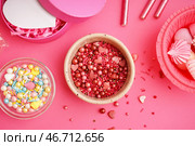 Миски с красочными сладкими посыпками, белковым кремом и украшениями на розовом фоне. Стоковое фото, фотограф Pixel_shot / Фотобанк Лори