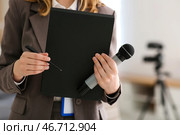 Красивая молодая женщина-репортер с микрофоном и блокнотом в офисе, крупным планом. Стоковое фото, фотограф Pixel_shot / Фотобанк Лори