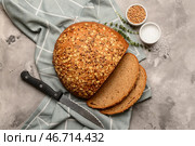 Нарезанный батон хлеба с зернами пшеницы, тимьяном и ножом на сером грубом фоне. Стоковое фото, фотограф Pixel_shot / Фотобанк Лори