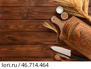 Доска с нарезанным батоном, колосьями пшеницы, зернами и тимьяном на деревянном фоне. Стоковое фото, фотограф Pixel_shot / Фотобанк Лори