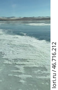 Vertical video of frozen Baikal Lake in winter. Traditional journey on beautiful blue ice of frozen Smal Sea to Olkhon Island Khuzhir village on sunny February day. Winter landscape. Natural background. Стоковое видео, видеограф Виктория Катьянова / Фотобанк Лори