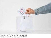 Голосующий мужчина рядом с избирательной урной на столе на белом фоне. Стоковое фото, фотограф Pixel_shot / Фотобанк Лори