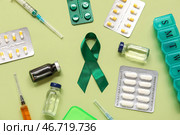 Атласная зеленая лента и медицинские принадлежности на цветном фоне, крупным планом. Национальный месяц осведомленности о церебральном параличе. Стоковое фото, фотограф Pixel_shot / Фотобанк Лори