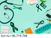Рамка из атласных зеленых лент и медицинских принадлежностей на бирюзовом фоне. Национальный месяц осведомленности о церебральном параличе. Стоковое фото, фотограф Pixel_shot / Фотобанк Лори