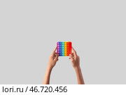 Ребенок с игрушкой-антистресс поп-ит на светлом фоне. Стоковое фото, фотограф Pixel_shot / Фотобанк Лори