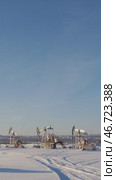 Oil pump jack extracting crude oil in a snowy landscape under a blue sky. Стоковое видео, видеограф Константин Шишкин / Фотобанк Лори