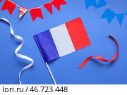 Флаг Франции с лентами и гирляндами на синем фоне. Празднование Дня взятия Бастилии. Стоковое фото, фотограф Pixel_shot / Фотобанк Лори