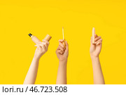 Женские руки с тональным кремом и консилером на жёлтом фоне. Стоковое фото, фотограф Pixel_shot / Фотобанк Лори