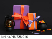 Подарочные коробки на Хэллоуин с фонарем, котлом и угощениями на черном фоне. Стоковое фото, фотограф Pixel_shot / Фотобанк Лори