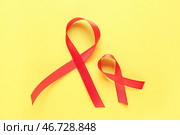 Красные ленты на желтом фоне. Всемирный день борьбы против рака. Стоковое фото, фотограф Pixel_shot / Фотобанк Лори