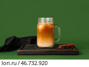 Банка с крышкой, наполненная айс-латте с корицей и кофейными зернами на зеленом фоне. Стоковое фото, фотограф Pixel_shot / Фотобанк Лори