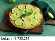 Деревянная доска с вкусным лаймовым тартом и мятой на зеленом фоне. Стоковое фото, фотограф Pixel_shot / Фотобанк Лори