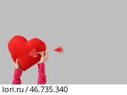 Женщина держит сердце с стрелой Купидона на светлом фоне. Празднование Дня святого Валентина. Стоковое фото, фотограф Pixel_shot / Фотобанк Лори