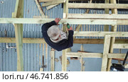 Aerial view of two senior men building a wooden frame house in the summer on their own location. Стоковое фото, фотограф David Kashakhi / Фотобанк Лори