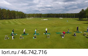 Golfers hitting golf shot with club on course while on summer vacation, aerial. Стоковое фото, фотограф David Kashakhi / Фотобанк Лори