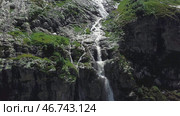 Waterfall flowing down from high mountains on a Sunny day. Стоковое фото, фотограф David Kashakhi / Фотобанк Лори