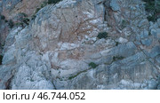 Top view of rocky steep wall with sparse vegetation on ledges. Стоковое фото, фотограф David Kashakhi / Фотобанк Лори