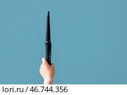 Женская рука с плойкой на голубом фоне. Стоковое фото, фотограф Pixel_shot / Фотобанк Лори