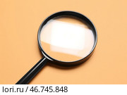Черное увеличительное стекло на оранжевом фоне. Стоковое фото, фотограф Pixel_shot / Фотобанк Лори