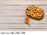 Доска с жареными луковыми кольцами в панировке и соусом на сером деревянном фоне. Стоковое фото, фотограф Pixel_shot / Фотобанк Лори