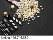 Попкорн, киношный хлопуш и хэллоуинская декорация на черном гранжевом фоне. Стоковое фото, фотограф Pixel_shot / Фотобанк Лори