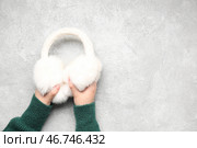 Женские руки с модными ушными муфтами на гранжевом фоне, крупным планом. Стоковое фото, фотограф Pixel_shot / Фотобанк Лори