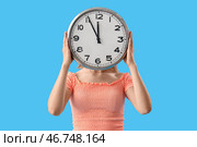 Молодая женщина с часами на голубом фоне. Концепция дедлайна. Стоковое фото, фотограф Pixel_shot / Фотобанк Лори