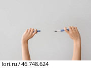 Женские руки с инсулиновым шприцем на сером фоне. Стоковое фото, фотограф Pixel_shot / Фотобанк Лори