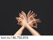 Стробоскопическое фото двигающейся женщины, показывающей "ОК" на темном фоне. Стоковое фото, фотограф Pixel_shot / Фотобанк Лори
