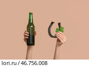 Руки с пивом, клевером и подковой на бежевом фоне. Празднование Дня святого Патрика. Стоковое фото, фотограф Pixel_shot / Фотобанк Лори