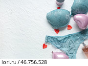 Сексуальное голубое нижнее белье с воздушными шариками в форме сердец и духами на белом текстурированном фоне. Празднование Дня святого Валентина. Стоковое фото, фотограф Pixel_shot / Фотобанк Лори