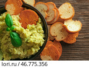 Чаша с вкусным гуакамоле и хлебными чипсами на деревянном фоне. Стоковое фото, фотограф Pixel_shot / Фотобанк Лори