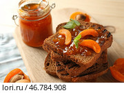 Поджаренный хлеб с вкусным абрикосовым джемом на деревянной доске. Стоковое фото, фотограф Pixel_shot / Фотобанк Лори