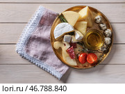Тарелка с ассортиментом вкусных сыров и масла на деревянном столе. Стоковое фото, фотограф Pixel_shot / Фотобанк Лори
