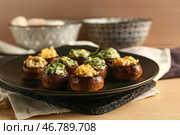 Тарелка с вкусными фаршированными грибами на столе. Стоковое фото, фотограф Pixel_shot / Фотобанк Лори