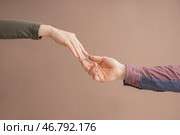 Мужчина и женщина, передавая друг другу руки на цветном фоне. Концепция поддержки и помощи. Стоковое фото, фотограф Pixel_shot / Фотобанк Лори