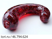 An object that resembles a large, curved capsule or organic form made of transparent, glass or resin material. Its color is a rich burgundy red with many textured inclusions that give it the effect of molten glass, caramel or biomaterial. The surface is glossy, reflecting light, creating a feeling of moisture or melting. The object resembles something biomechanical or futuristic, as if from a science fiction world. Стоковое AI-изображение, AI-художник Анна Кривицкая / Фотобанк Лори