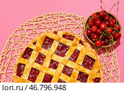 Плетеная циновка с вкусным вишневым пирогом на цветном фоне. Стоковое фото, фотограф Pixel_shot / Фотобанк Лори