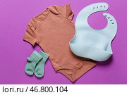 Детская одежда и слюнявчик на цветном фоне. Стоковое фото, фотограф Pixel_shot / Фотобанк Лори