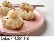 Тарелка с вкусными пельменями и палочками для еды на светлом деревянном фоне, крупным планом. Стоковое фото, фотограф Pixel_shot / Фотобанк Лори