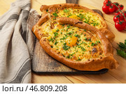 Доска с вкусными хачапури по-аджарски на деревянном фоне. Стоковое фото, фотограф Pixel_shot / Фотобанк Лори