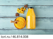 Бутылка здорового напитка из куркумы и миска с порошком на цветном деревянном фоне. Стоковое фото, фотограф Pixel_shot / Фотобанк Лори