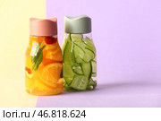 Спортивные бутылки с водой с добавлением различных нарезанных фруктов на ярком фоне. Стоковое фото, фотограф Pixel_shot / Фотобанк Лори