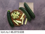 Свежая зеленая цуккини и доска с нарезанными кольцами на фиолетовом фоне. Стоковое фото, фотограф Pixel_shot / Фотобанк Лори