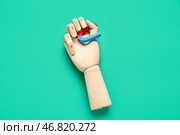 Деревянная рука с мини-магнитом в форме подковы на зеленом фоне. Стоковое фото, фотограф Pixel_shot / Фотобанк Лори