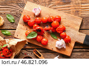 Доска со шпажками с вкусными жареными помидорами и базиликом на деревянном фоне. Стоковое фото, фотограф Pixel_shot / Фотобанк Лори