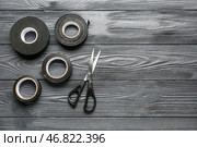 Рулончики скотча и канцелярские ножницы на сером деревянном фоне. Стоковое фото, фотограф Pixel_shot / Фотобанк Лори