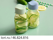 Бутылки для воды с добавлением огуречного напитка на зеленом фоне. Стоковое фото, фотограф Pixel_shot / Фотобанк Лори