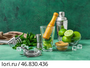 Стакан с толкушкой и ингредиенты для приготовления мохито на столе. Стоковое фото, фотограф Pixel_shot / Фотобанк Лори